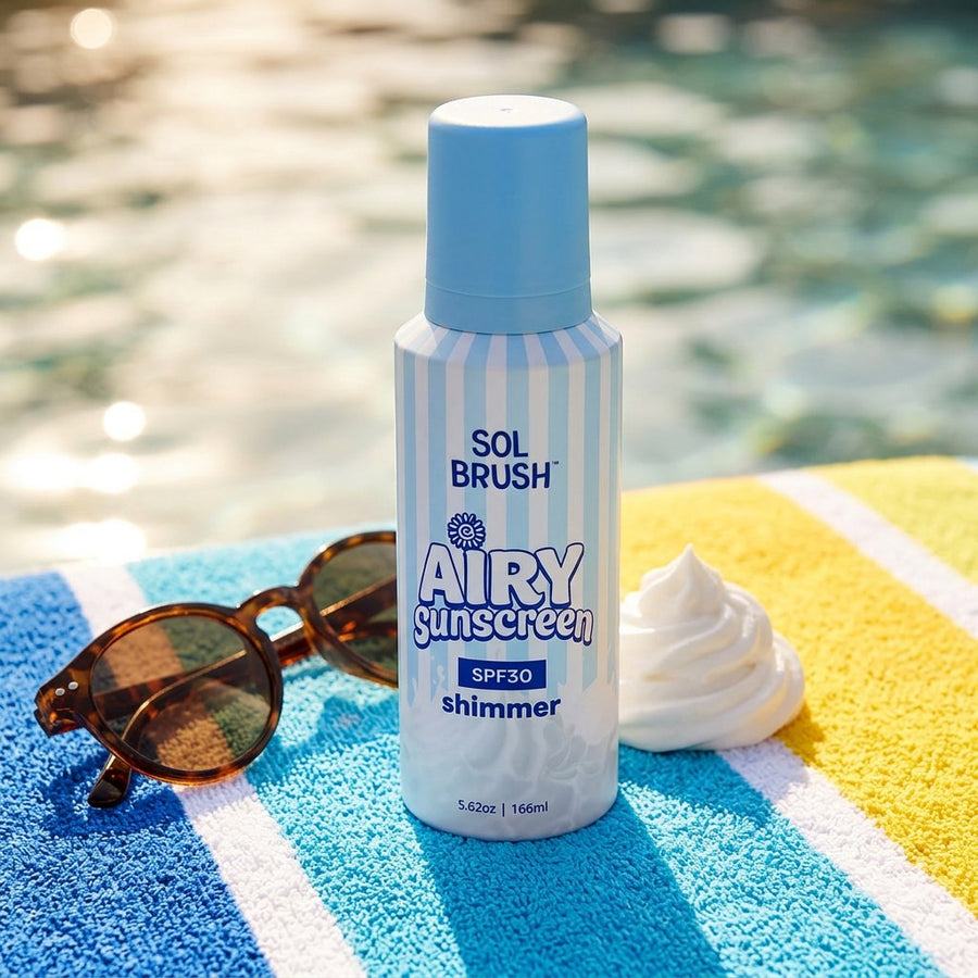 Airy Sunscreen SPF 30 bottle in blue stripes on a beach towel with sunglasses and a dollop of its whipped texture