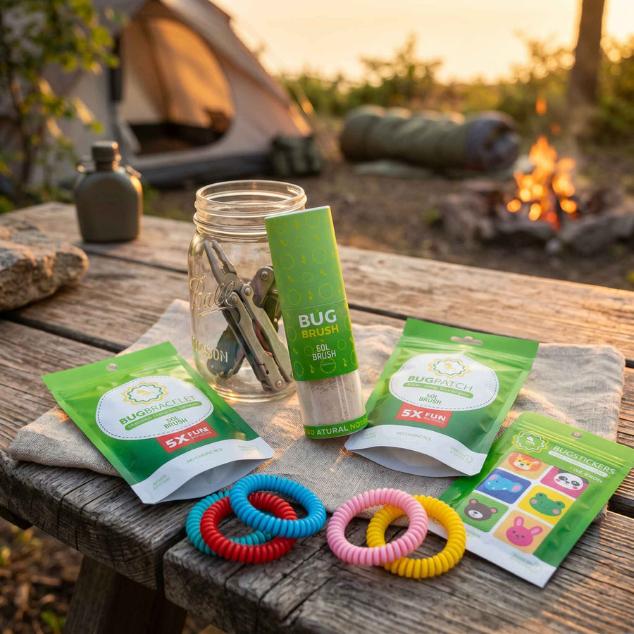 Bug Brush bundle on a camp table at dusk: repellent brush, bracelets, patches, and stickers by a tent