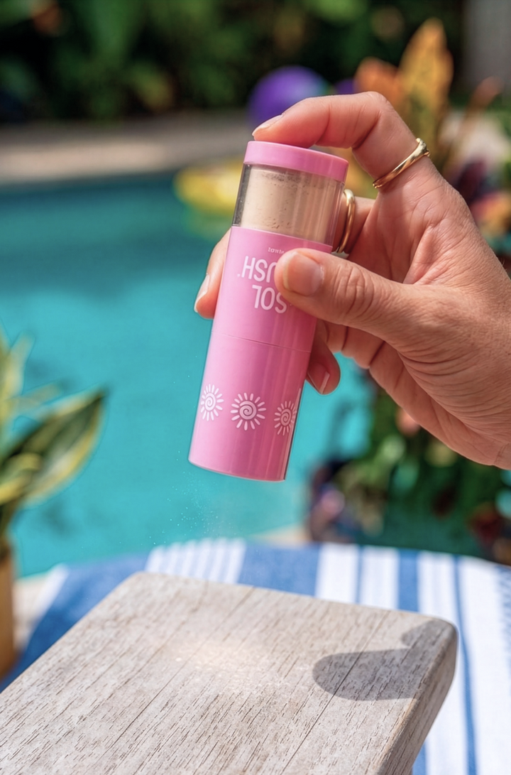 Hand holding a pink Sol Brush upside down, ready to slam it on a table